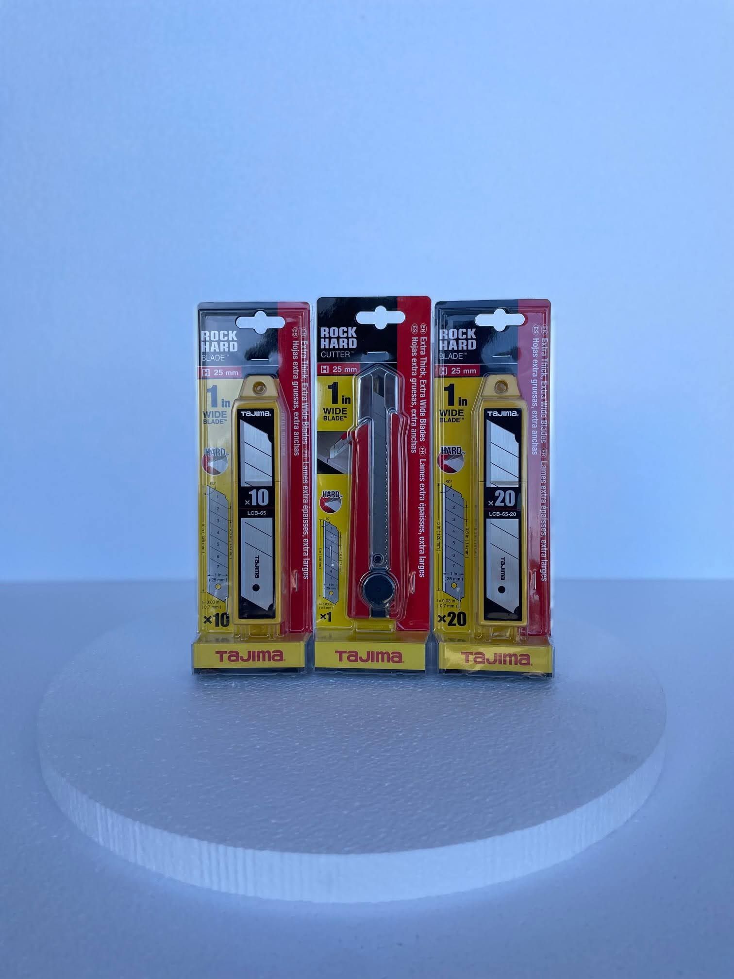 Three knives are sitting on top of each other on a table.