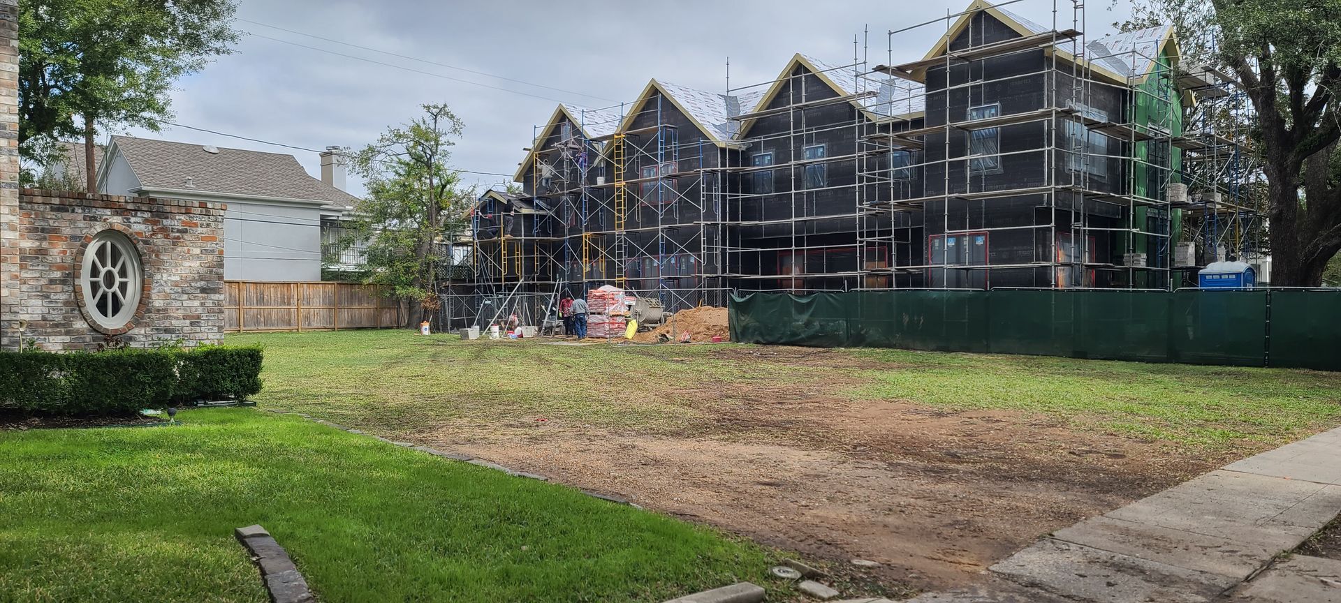 A row of houses are being built in a residential area.