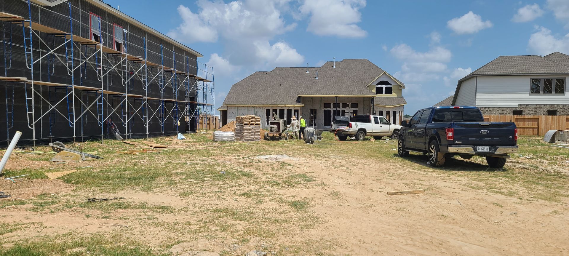 A truck is parked in front of a house under construction.