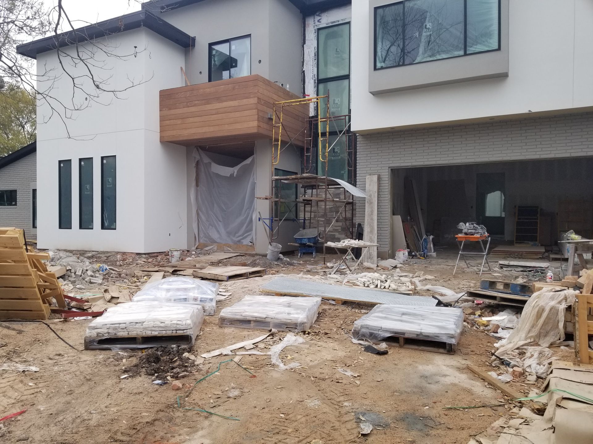 A house is being built with a lot of pallets in front of it.