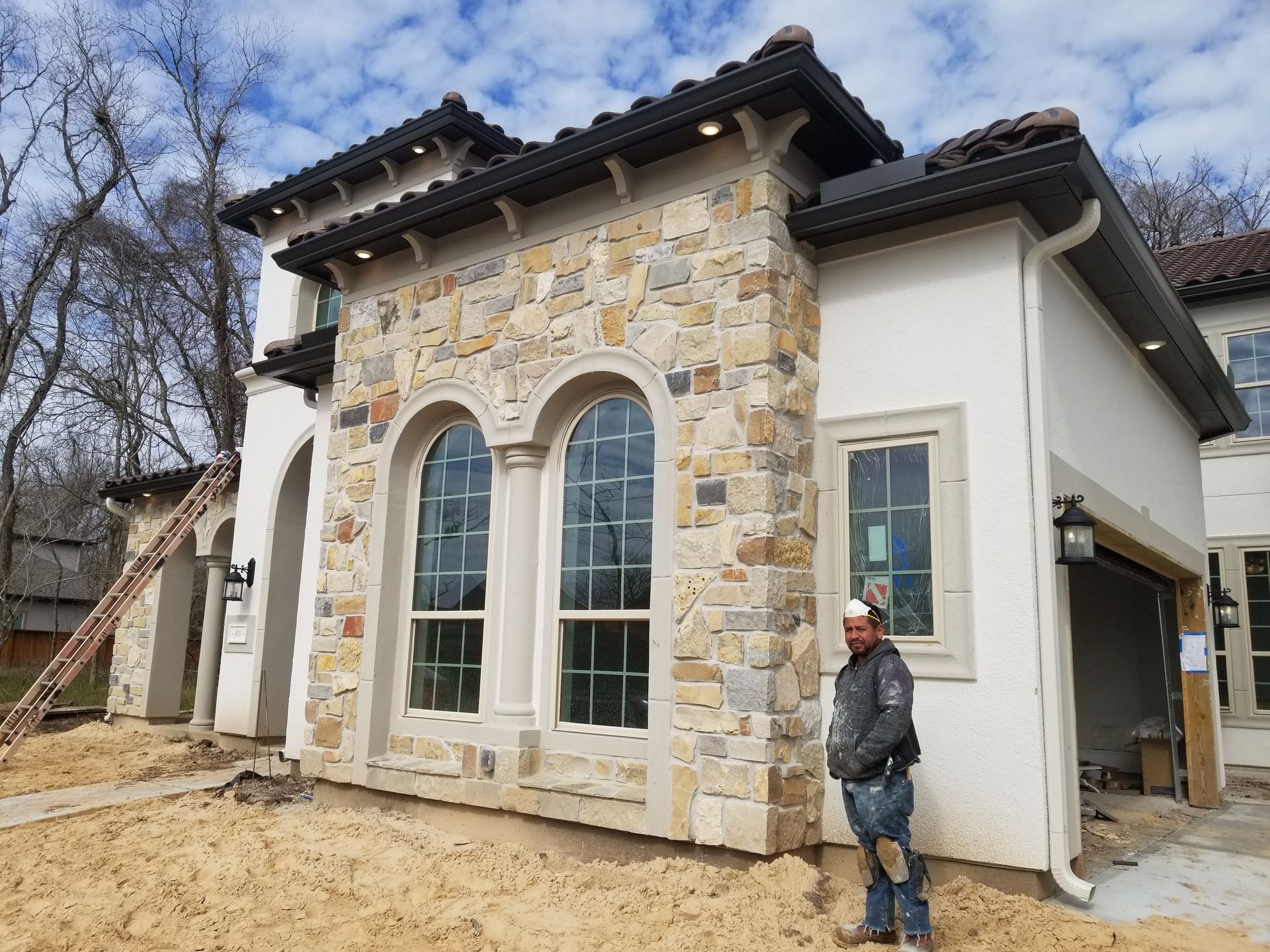 A man is standing in front of a house that is being built.