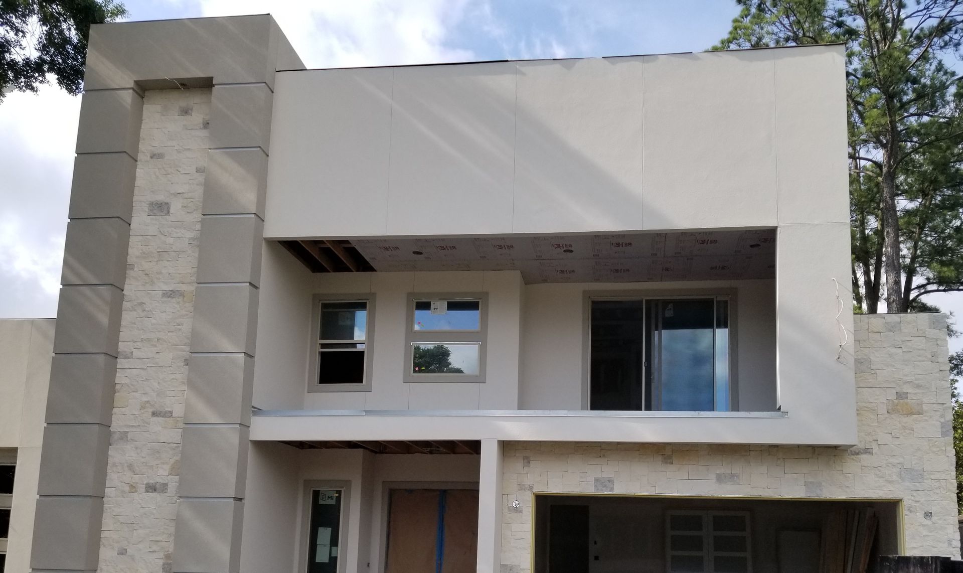 A large white house with a garage underneath it