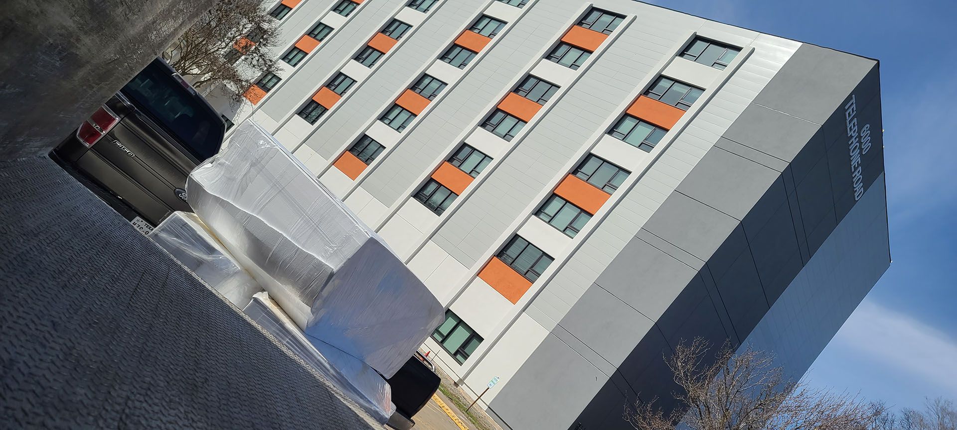A large building with a lot of windows and a blue sky in the background.