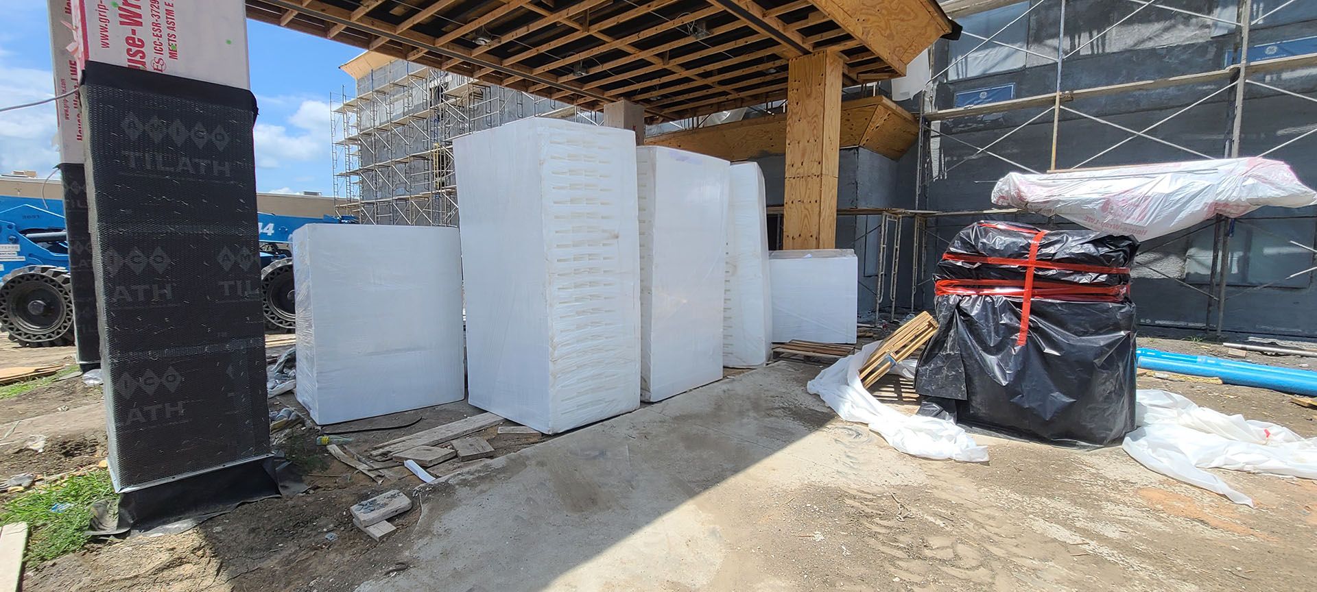 A building under construction with a lot of white blocks on the ground.