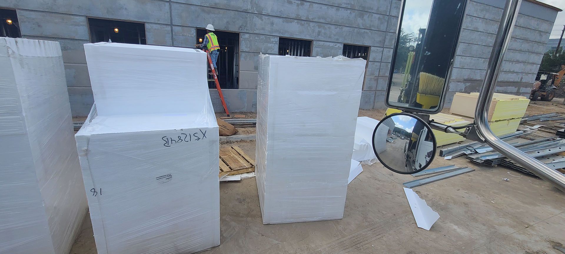 A stack of styrofoam blocks sitting in front of a building under construction.