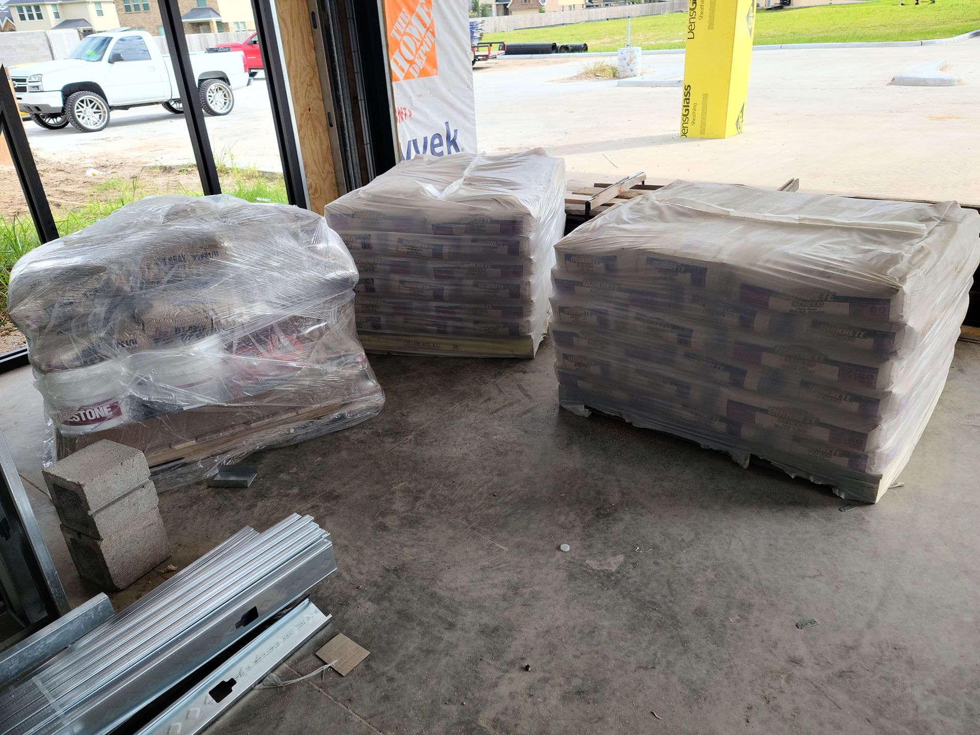 A warehouse filled with lots of bricks wrapped in plastic.