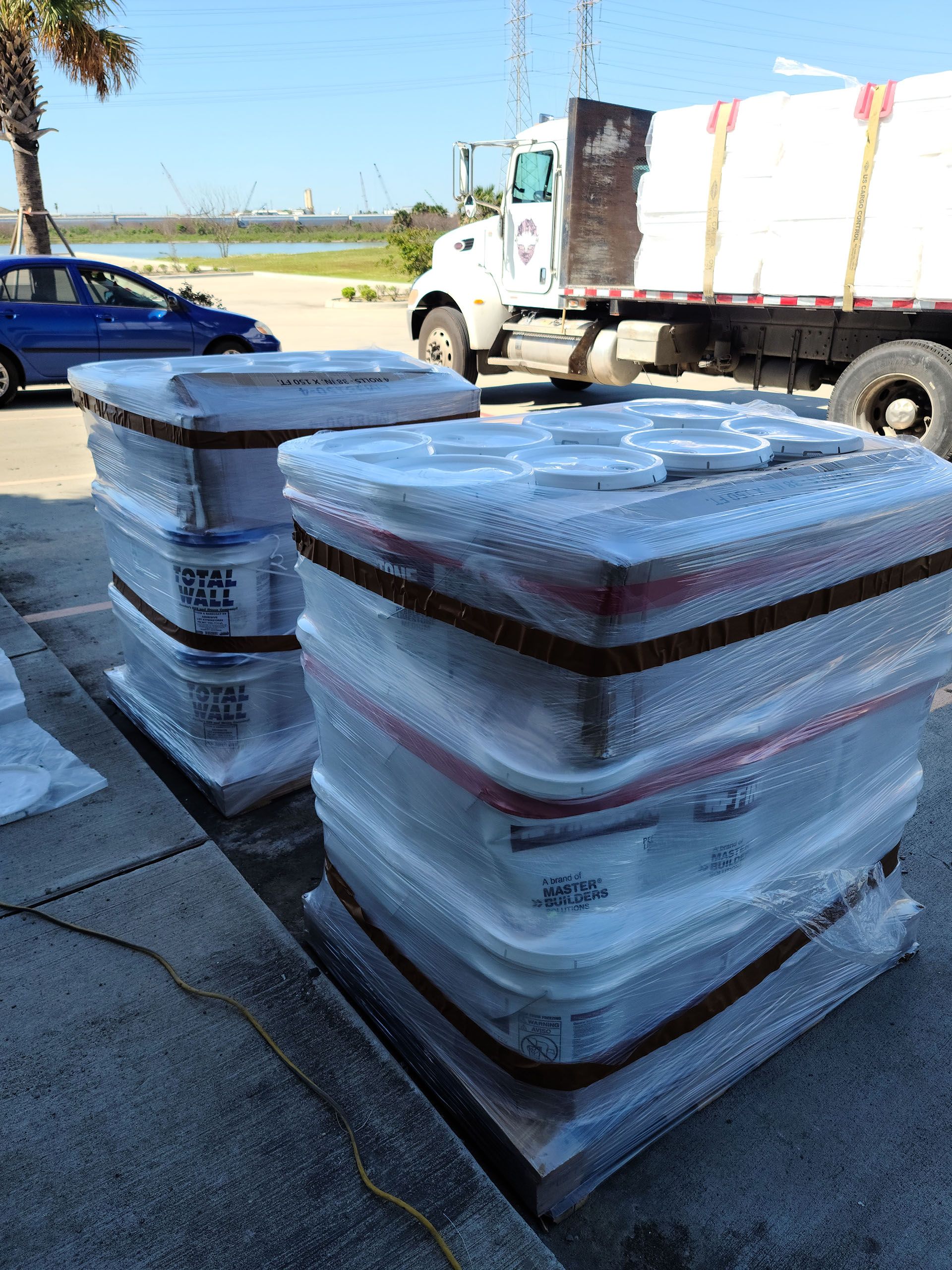 A stack of plastic containers on a pallet next to a truck.