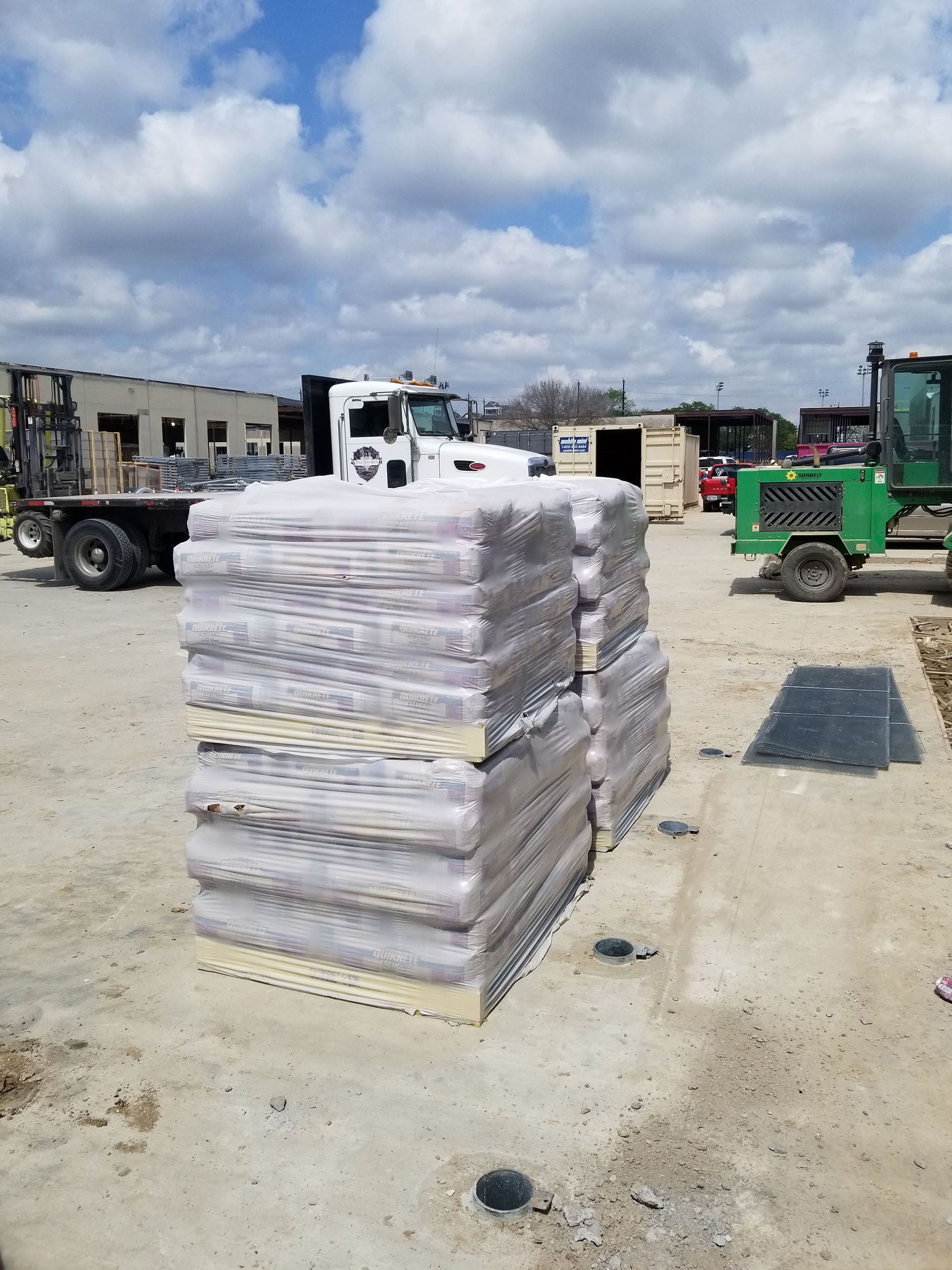 A stack of bags sitting on top of each other in a dirt field.