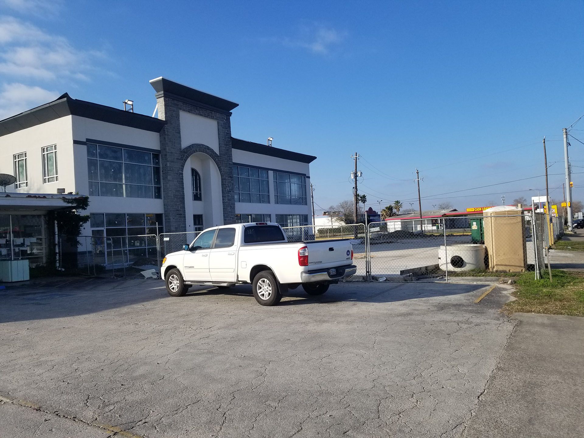 A white truck is parked in front of a building.