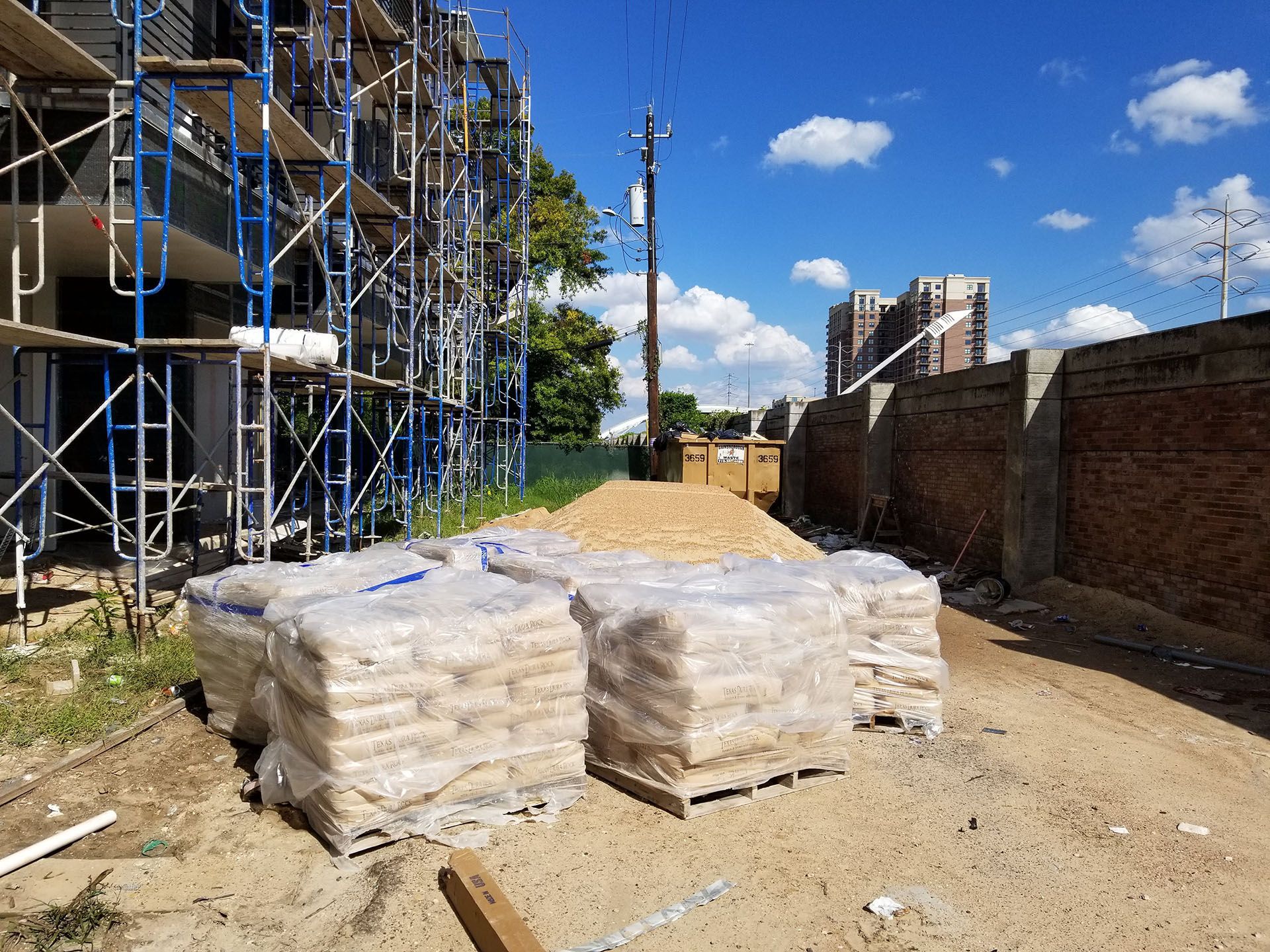 A construction site with scaffolding and bags of sand.