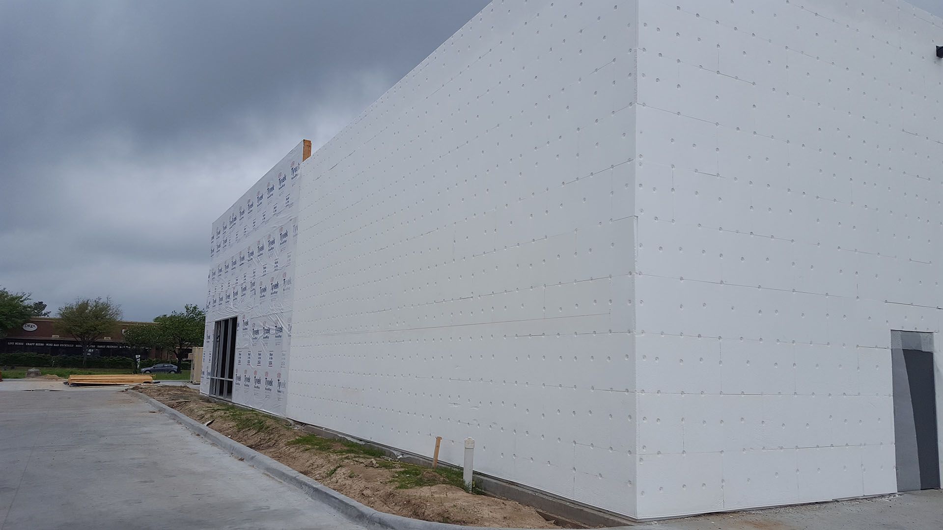 A large white building is being built on a cloudy day.
