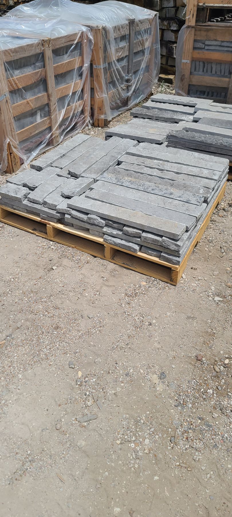 A wooden pallet filled with bricks is sitting on the ground.