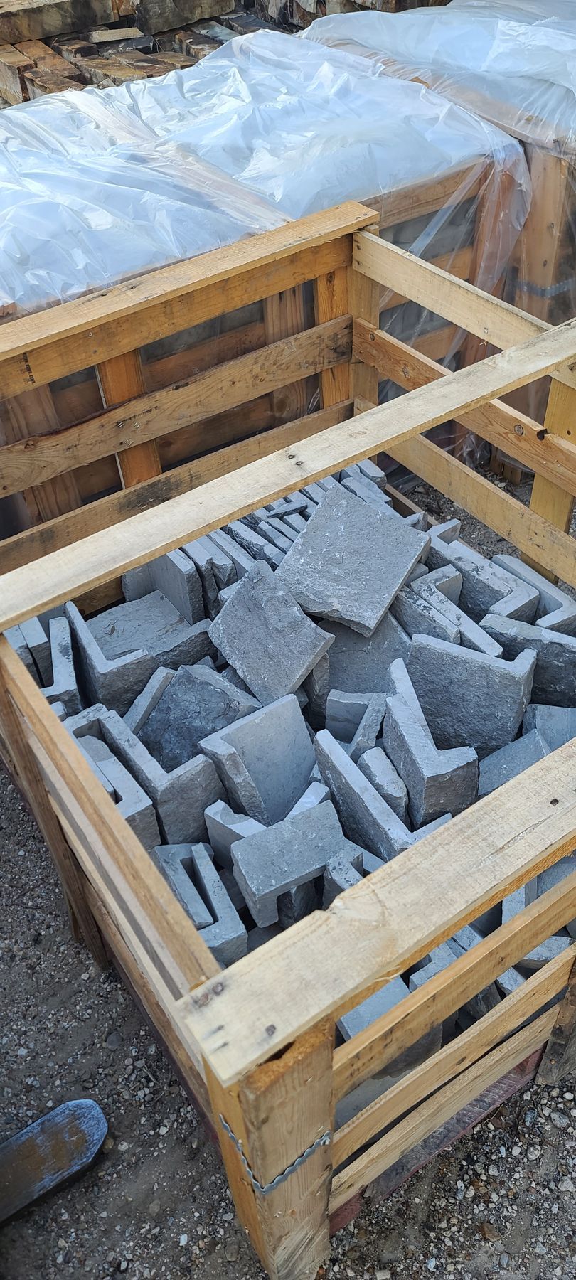 A wooden crate filled with concrete blocks is sitting on the ground.