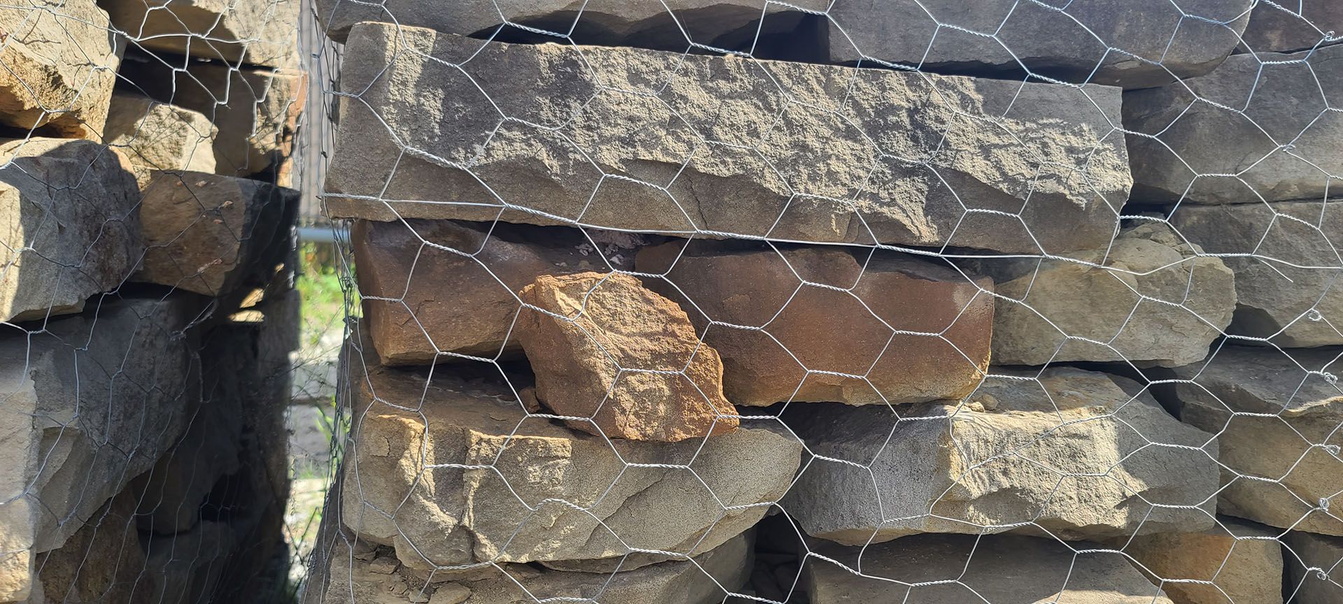 A pile of rocks behind a chicken wire fence