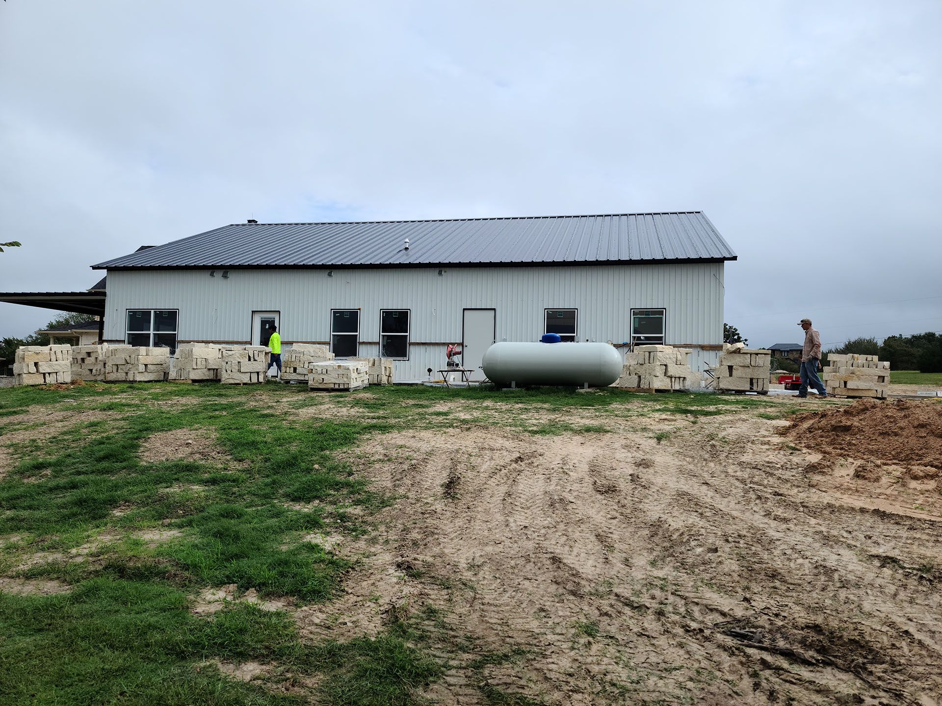 A large white building with a propane tank in front of it.