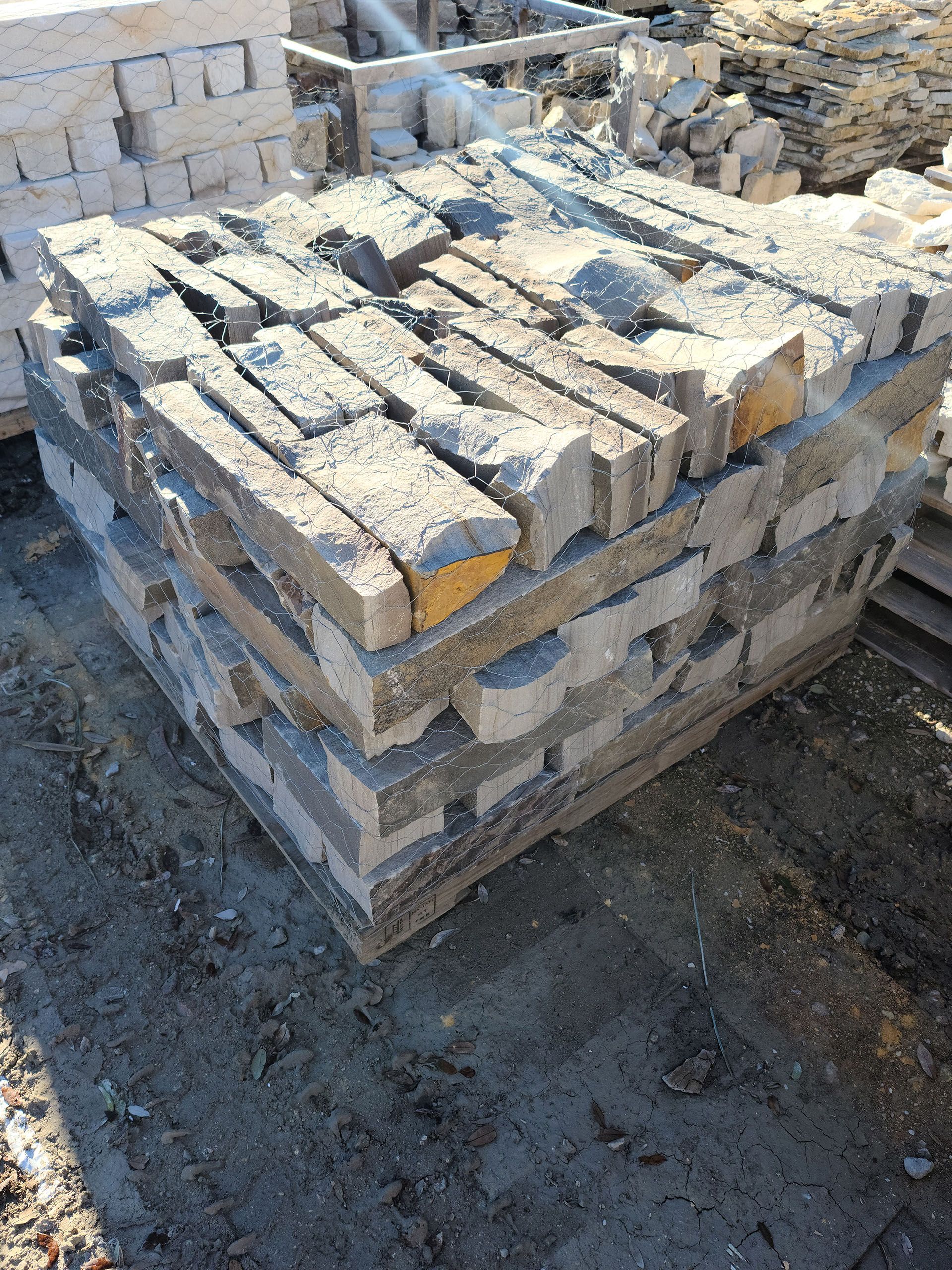 A pile of bricks sitting on top of each other on the ground.