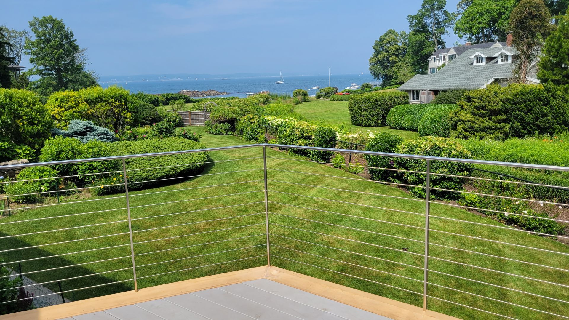 A view of the ocean from a balcony with a stainless steel railing.
