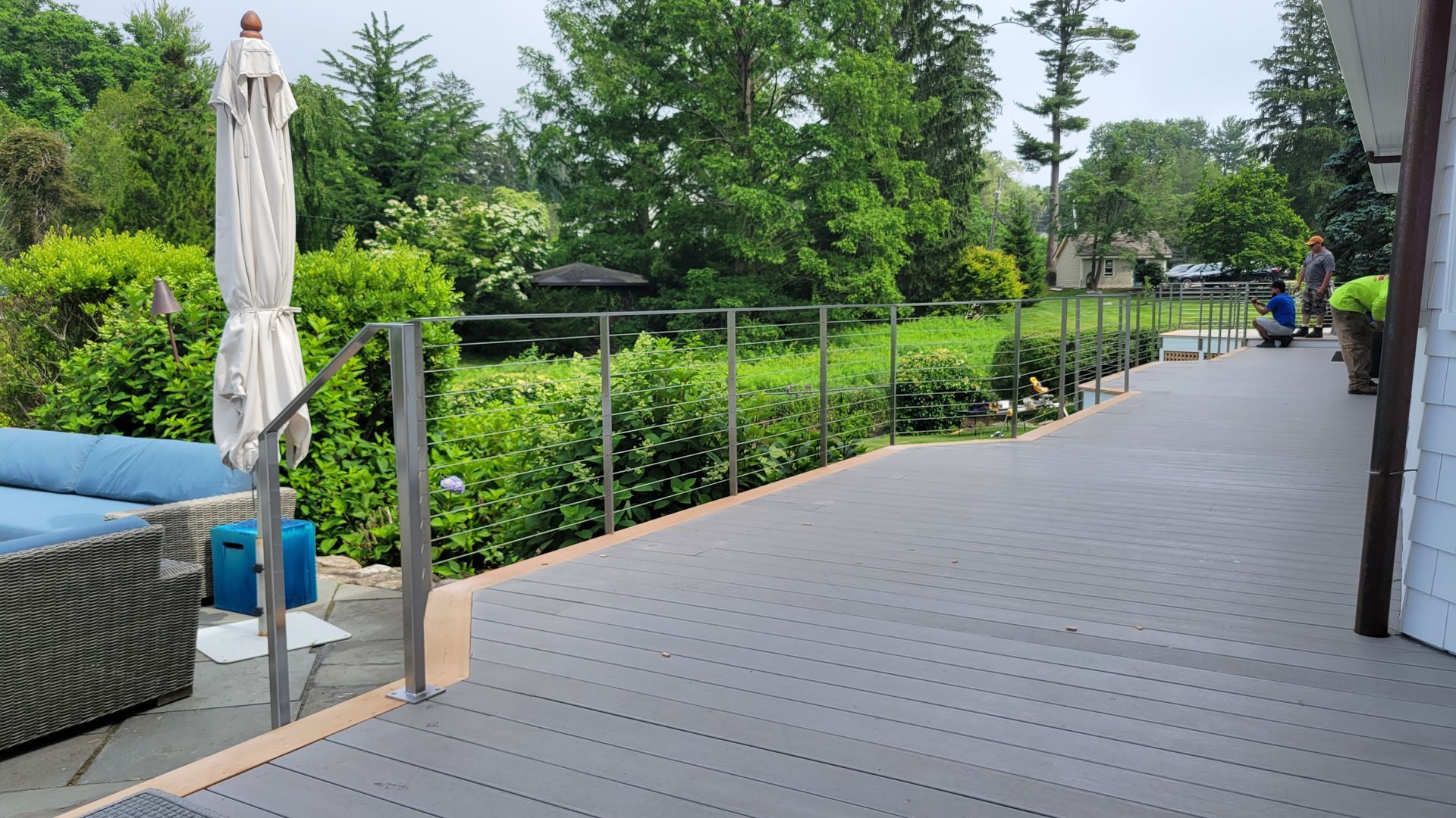 A patio with a blue couch and a white umbrella.