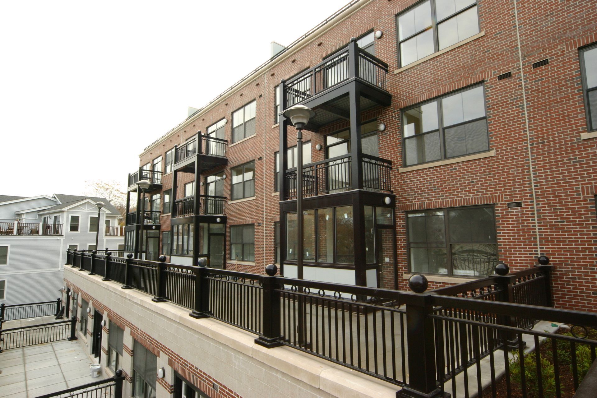A brick building with balconies and a black railing