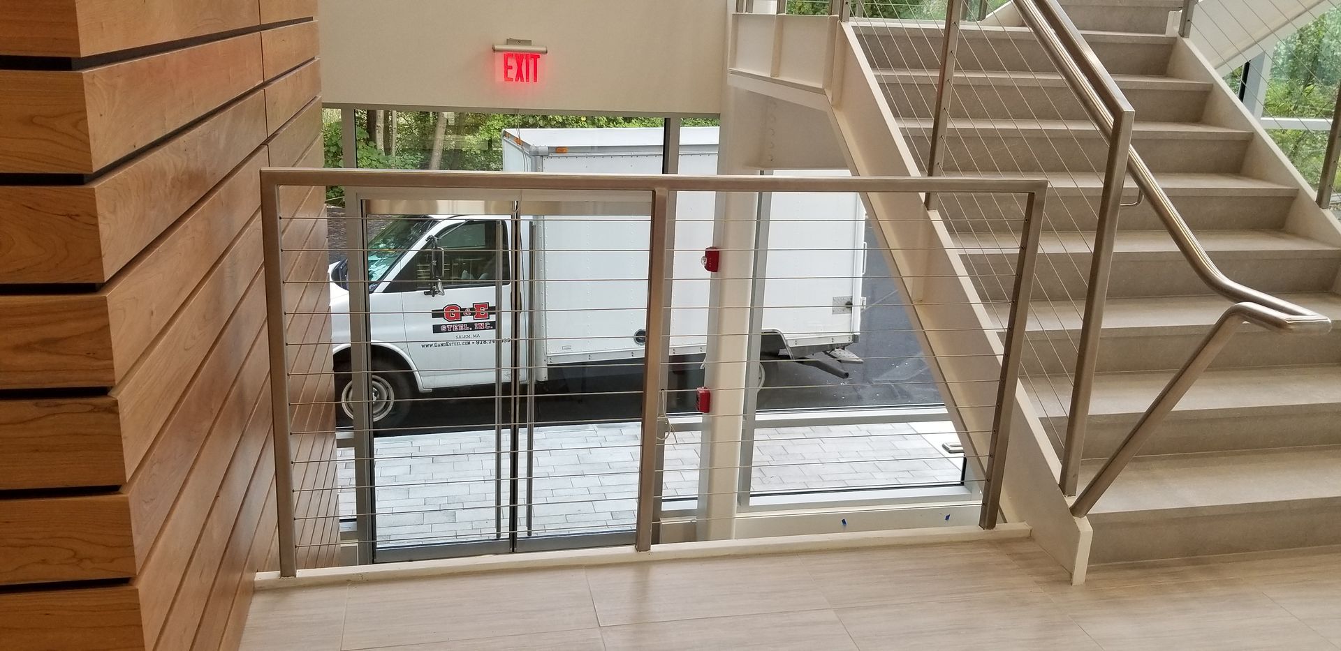 A white van is parked in front of a set of stairs.