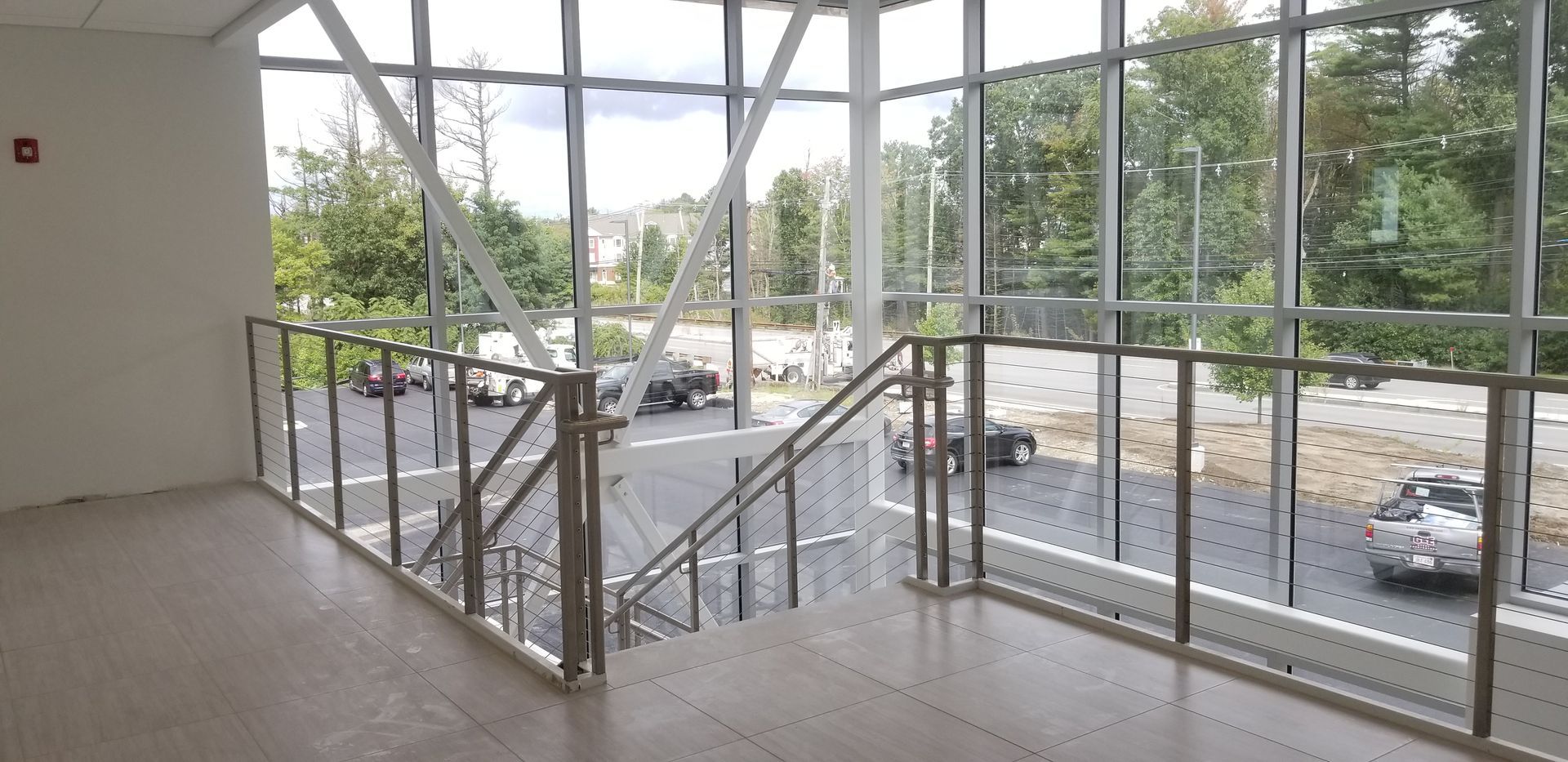 An empty room with stairs and a large window.