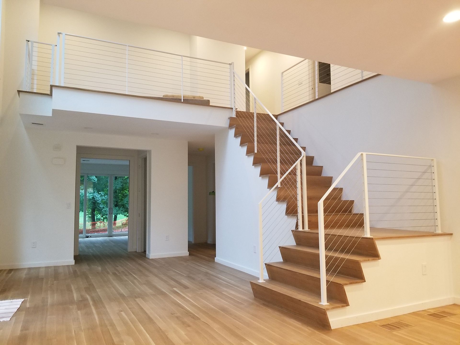 An empty room with a staircase and a balcony