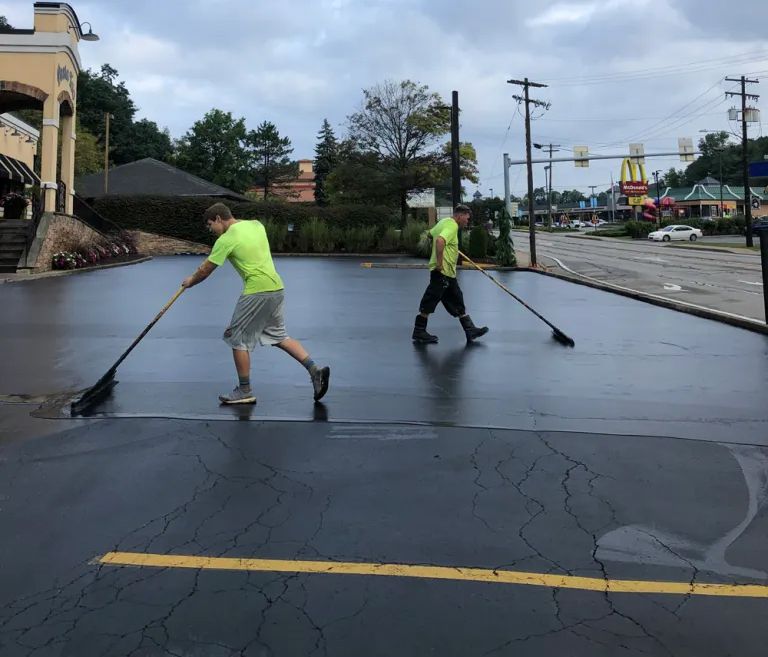 Workers working on a commercial sealcoating service.