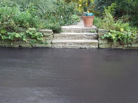 Stone steps leading to a garden with a potted plant above a dark pond or canal