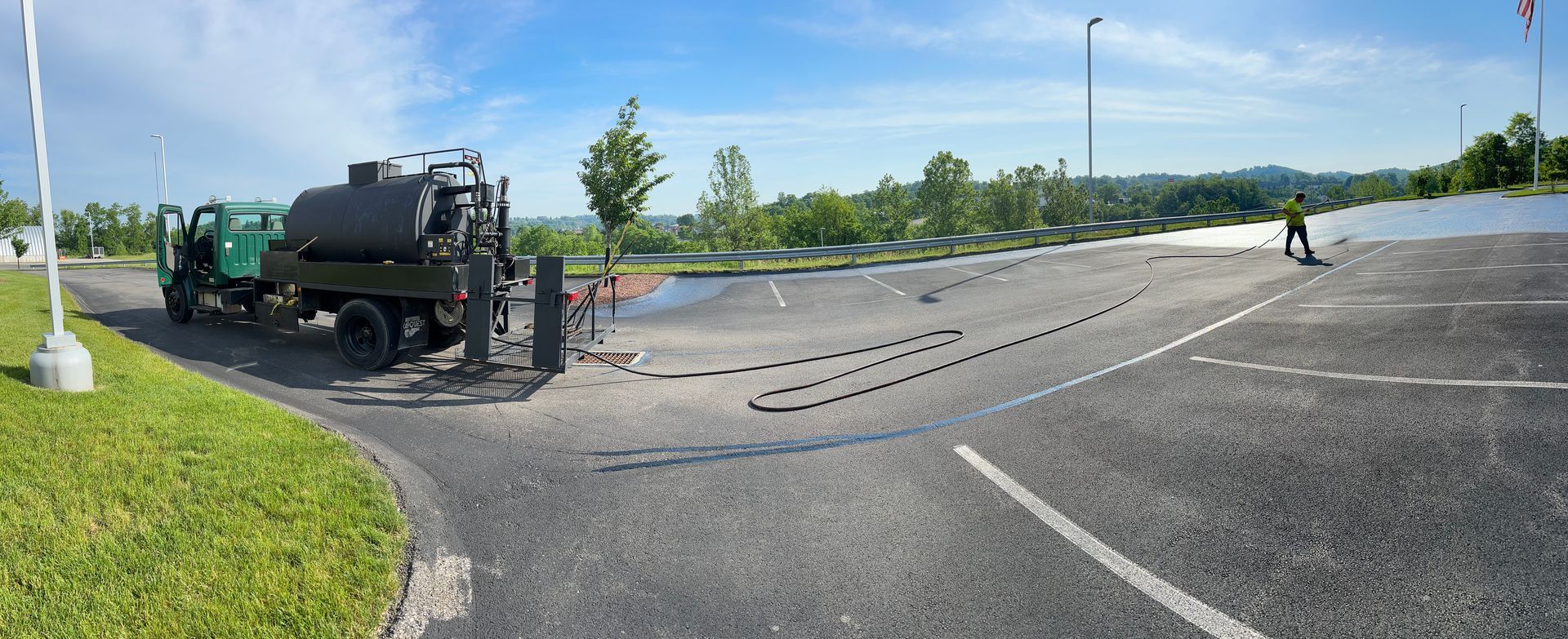 Overturned black truck blocking a road, with debris scattered across the pavement on a sunny day
