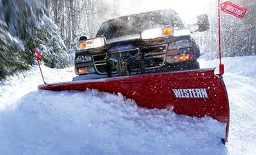 Snowplow truck plowing a snow-covered road