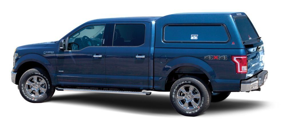 Blue Ford F-150 pickup truck with a blue camper shell.