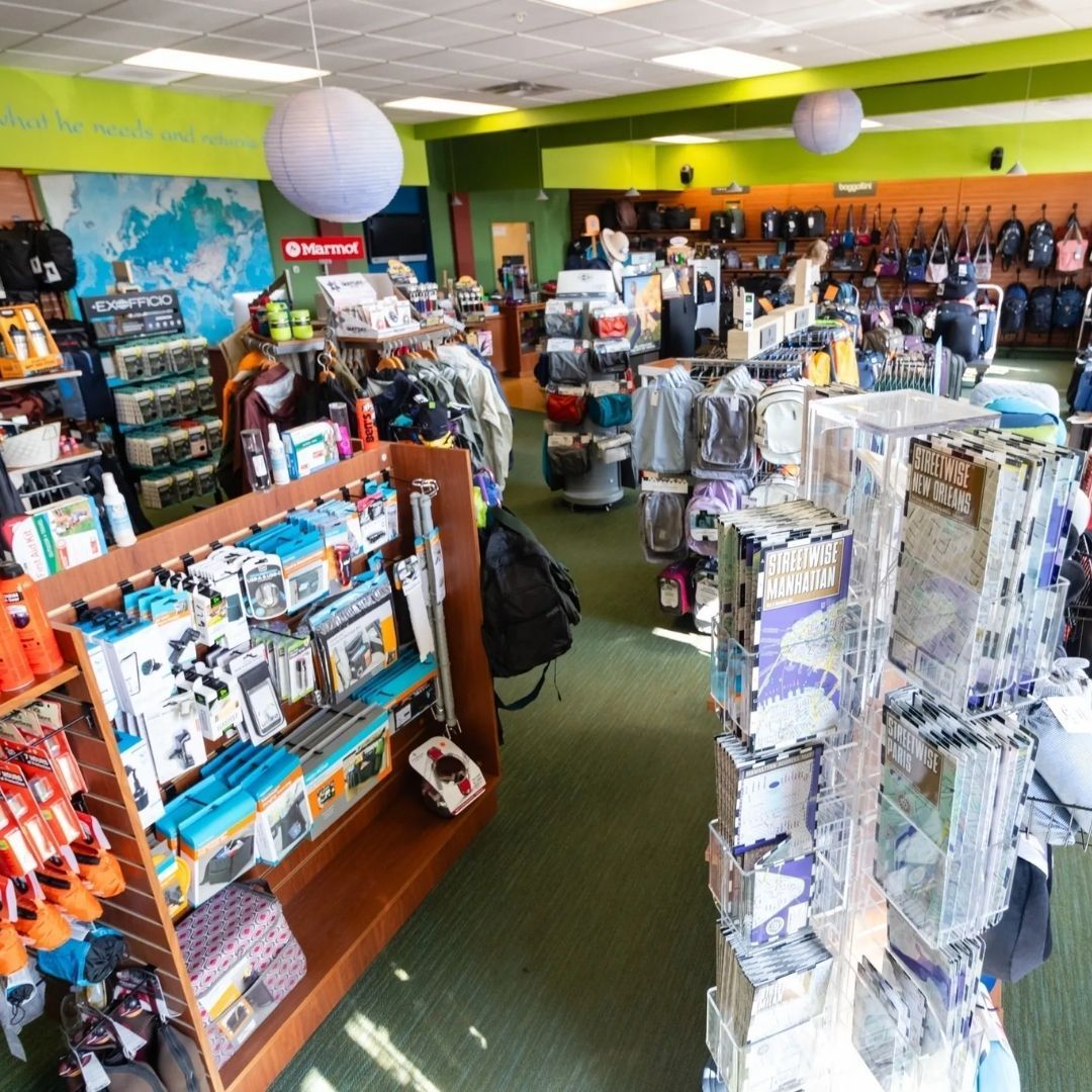 Interior of an outdoor retail store with shelves stocked with camping gear, equipment, and backpacks.