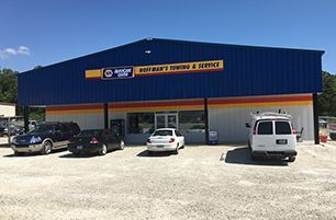 Learn more about Brake Service Blue auto repair shop with NAPA sign; cars parked outside.