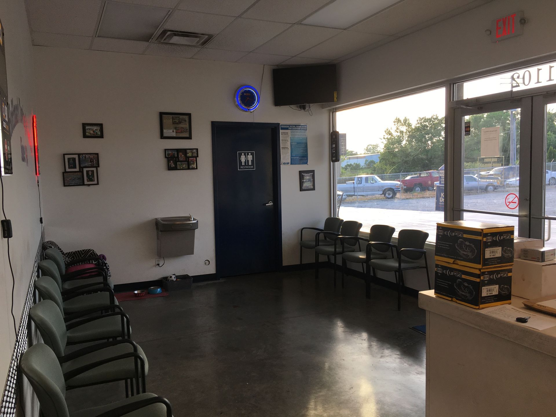 Waiting room with chairs, a door, and a window looking out at parked cars.