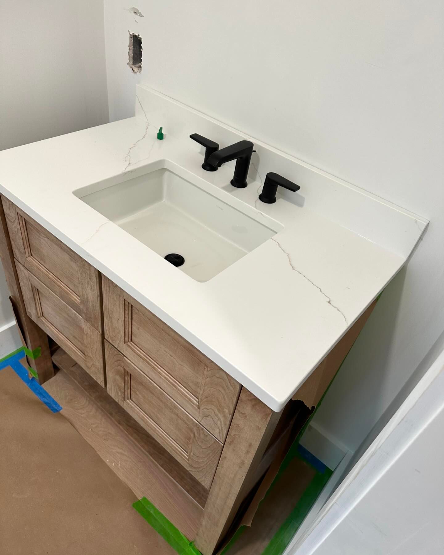 A bathroom sink with a wooden cabinet and a white counter top.