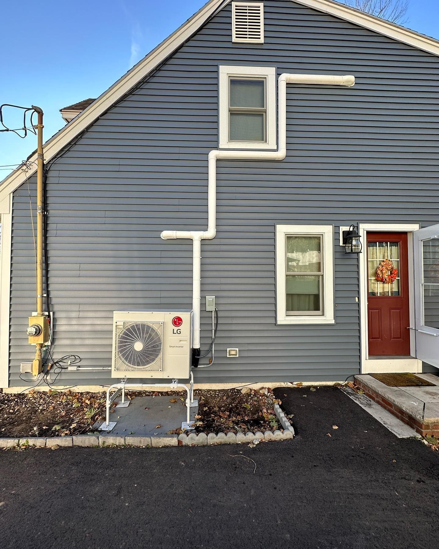 An lg air conditioner is mounted on the side of a house