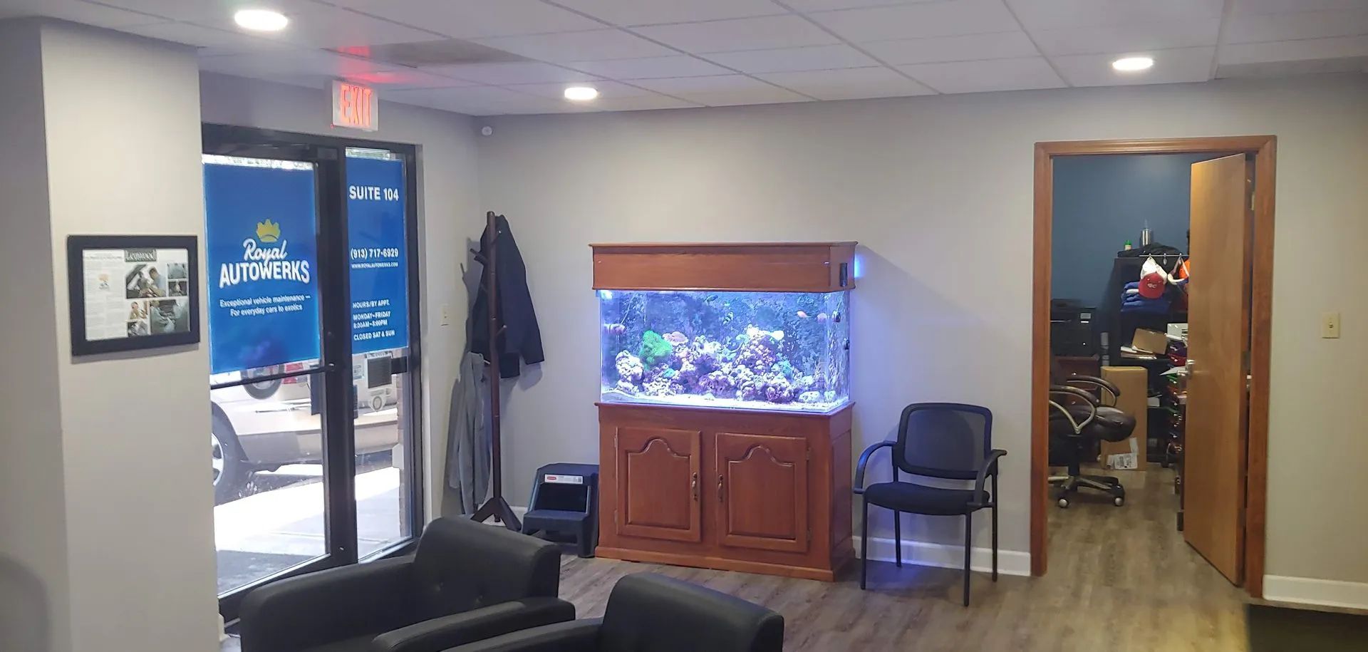 Office waiting area with aquarium, chairs, and open door.