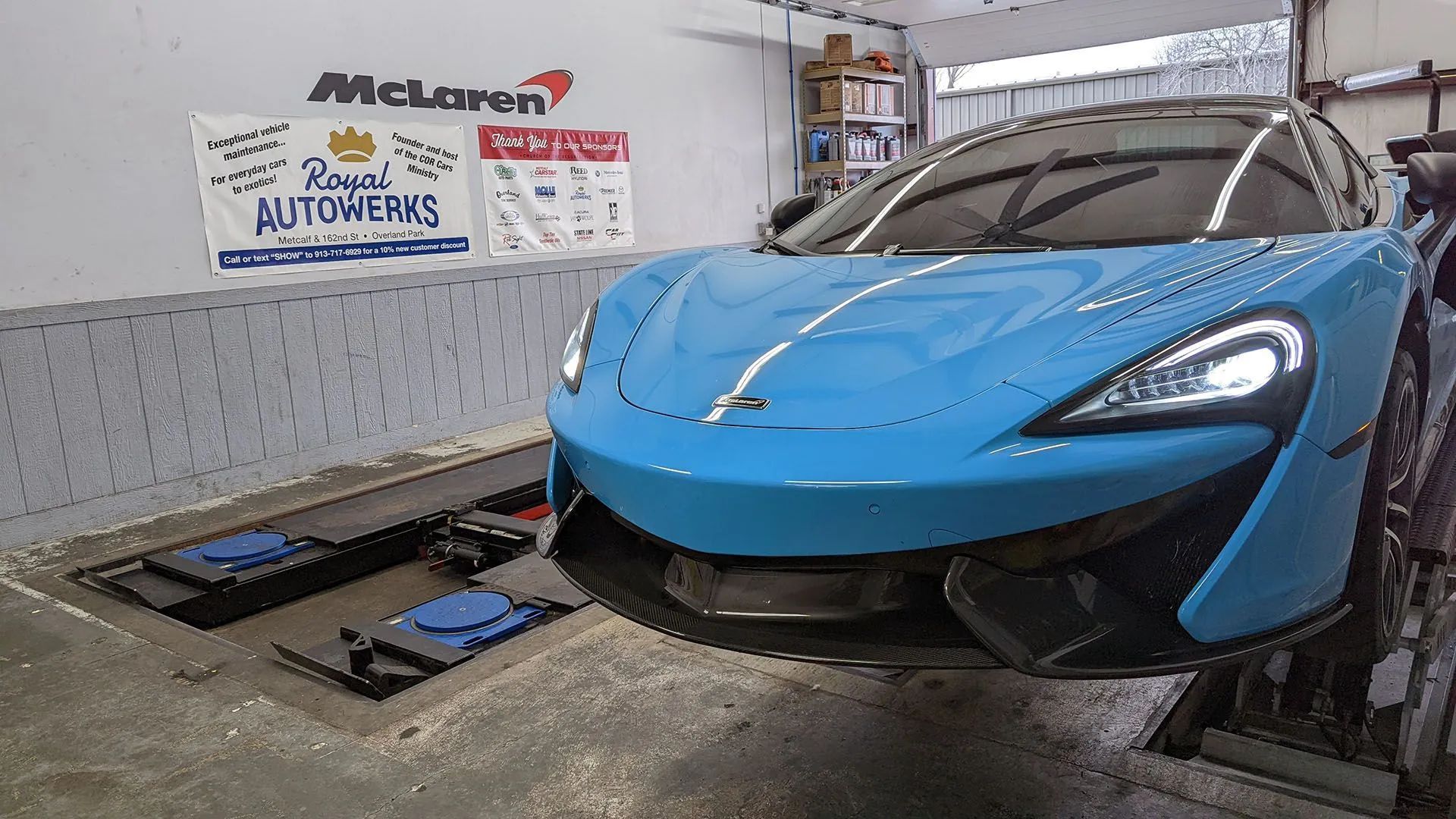 Blue McLaren sports car in a garage with 