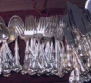 A bunch of silverware is sitting on a table.
