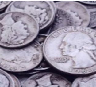A pile of silver coins with one that says liberty on it