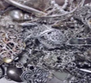 A pile of silver jewelry is sitting on a table.