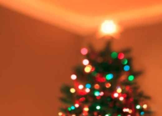 Blurred Christmas tree with colorful lights glowing in a warm room