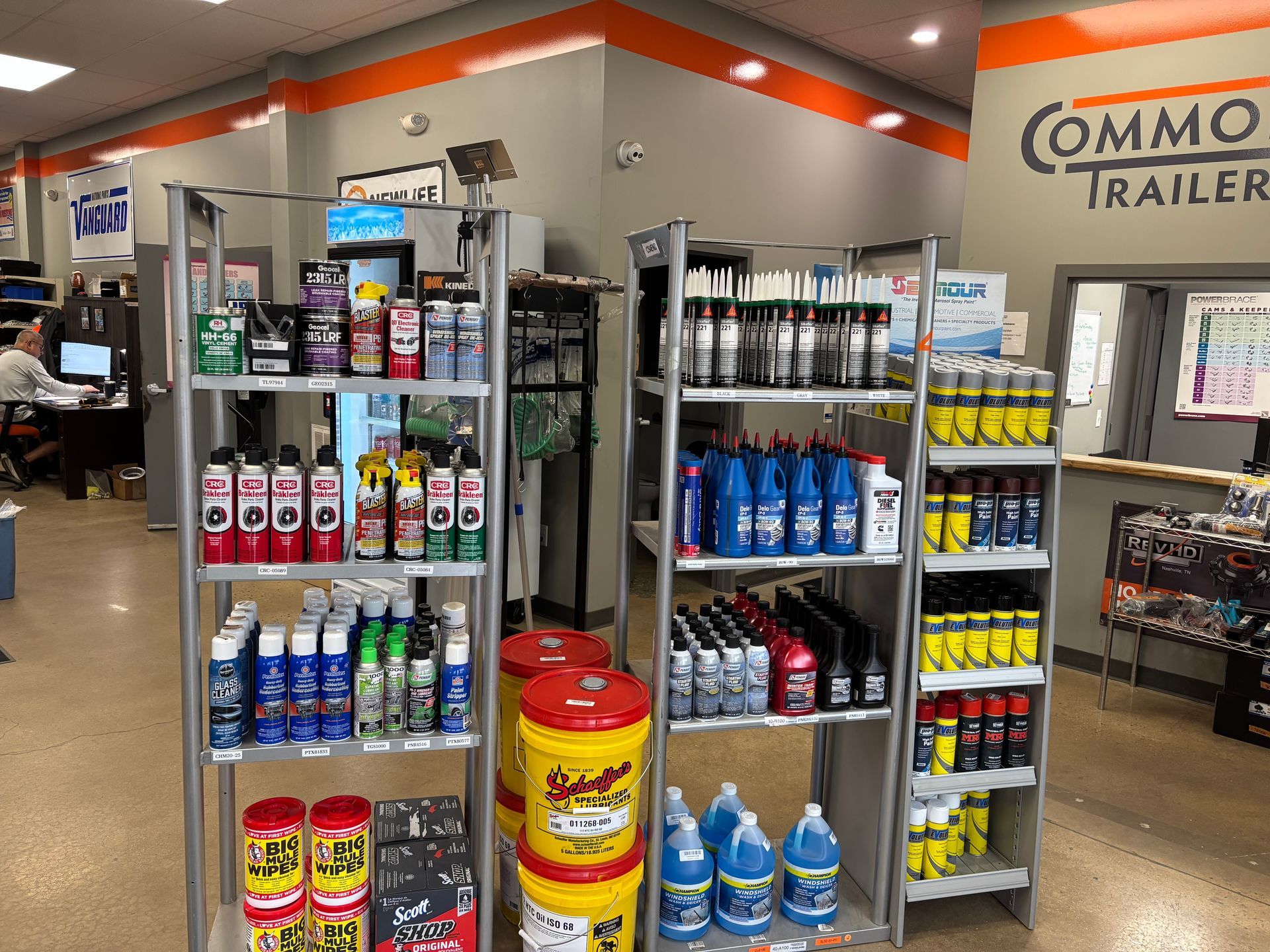 Trailer shop interior with shelves of automotive fluids, oils, and supplies