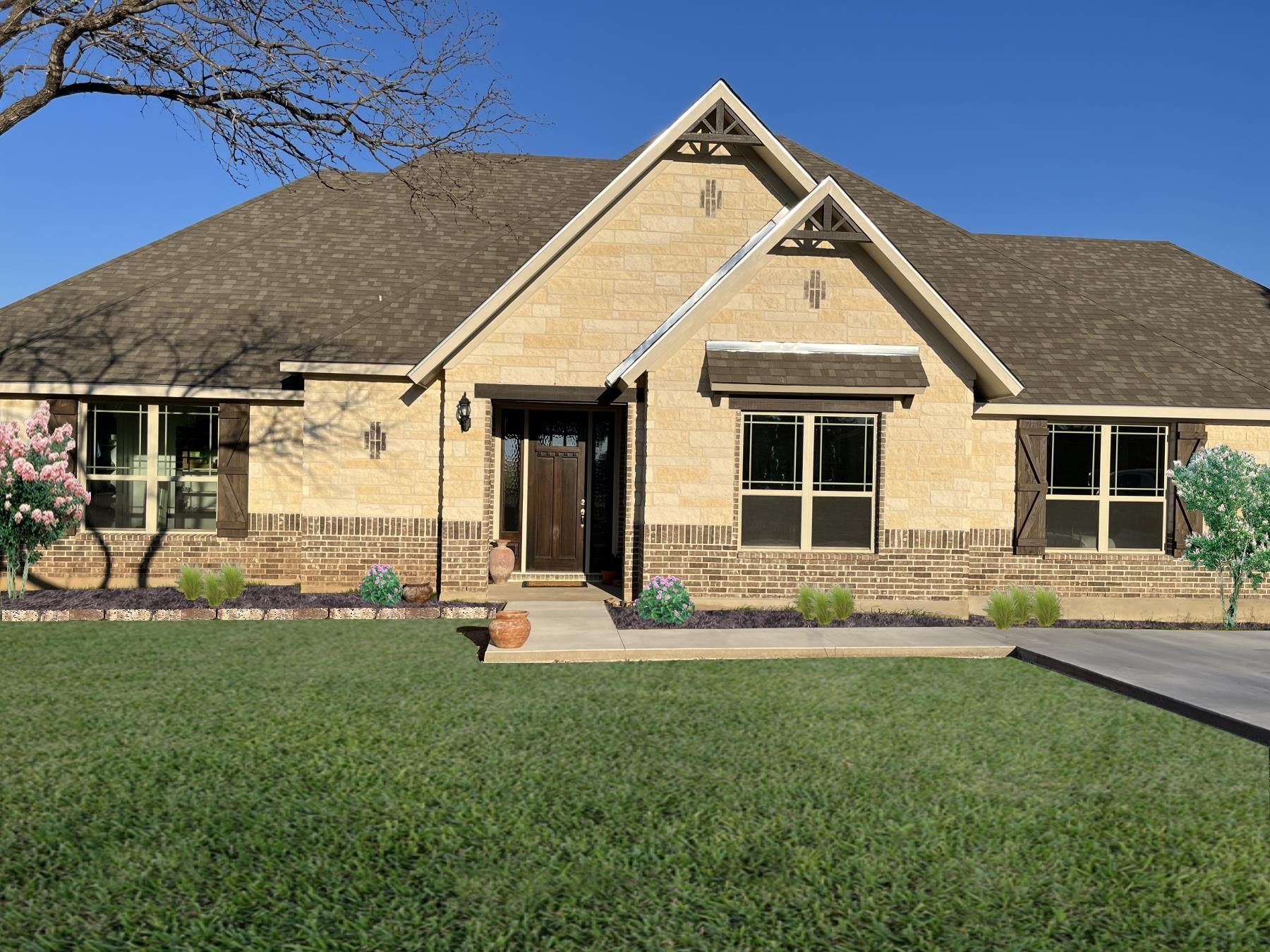 Tan brick house with brown roof and trim, green lawn, and blue sky.