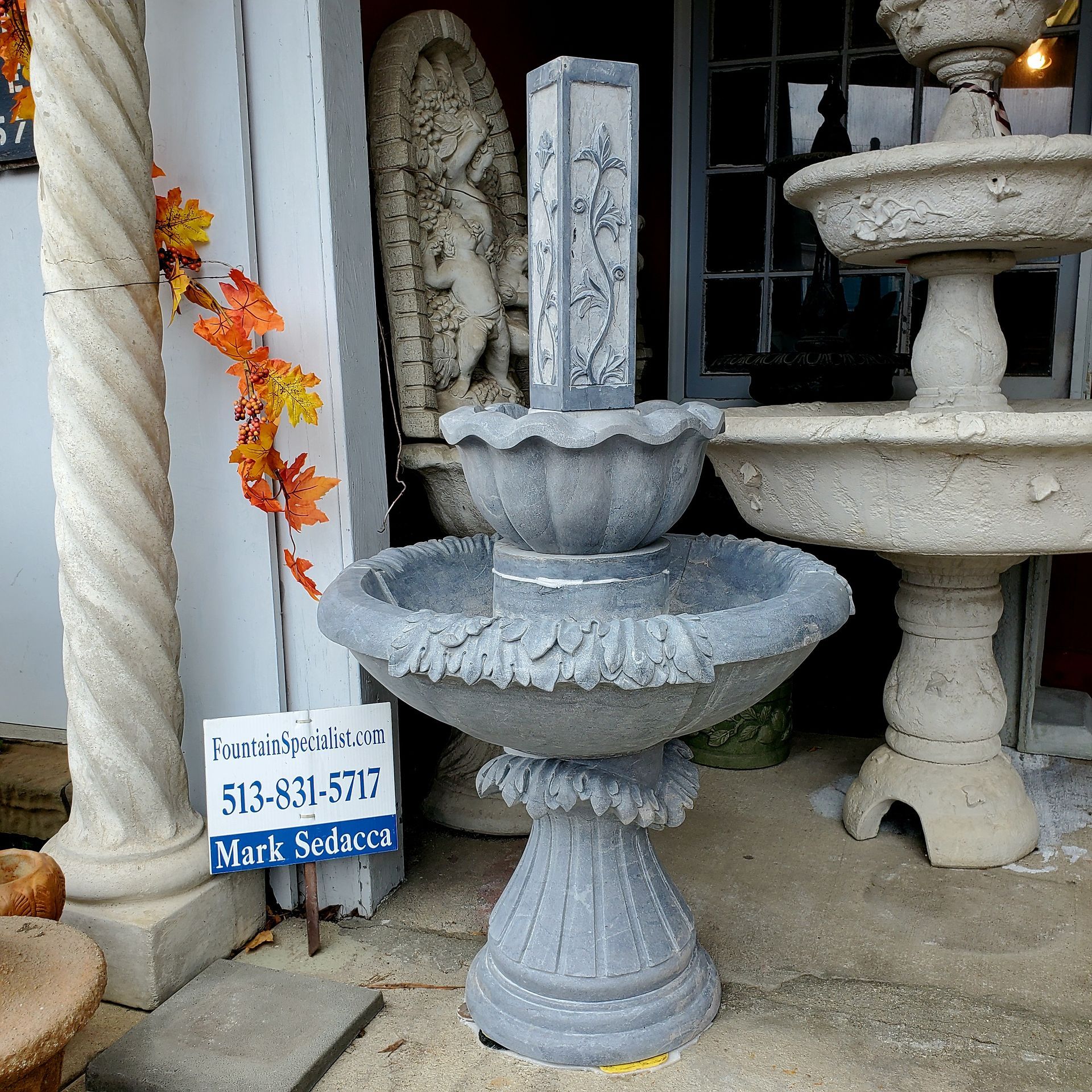 A fountain sits in front of a sign that says mark solucius