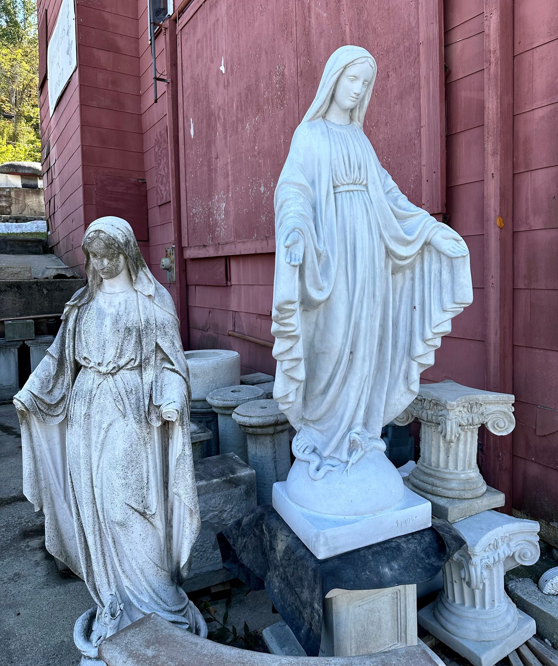 A statue of a woman standing in front of a red building