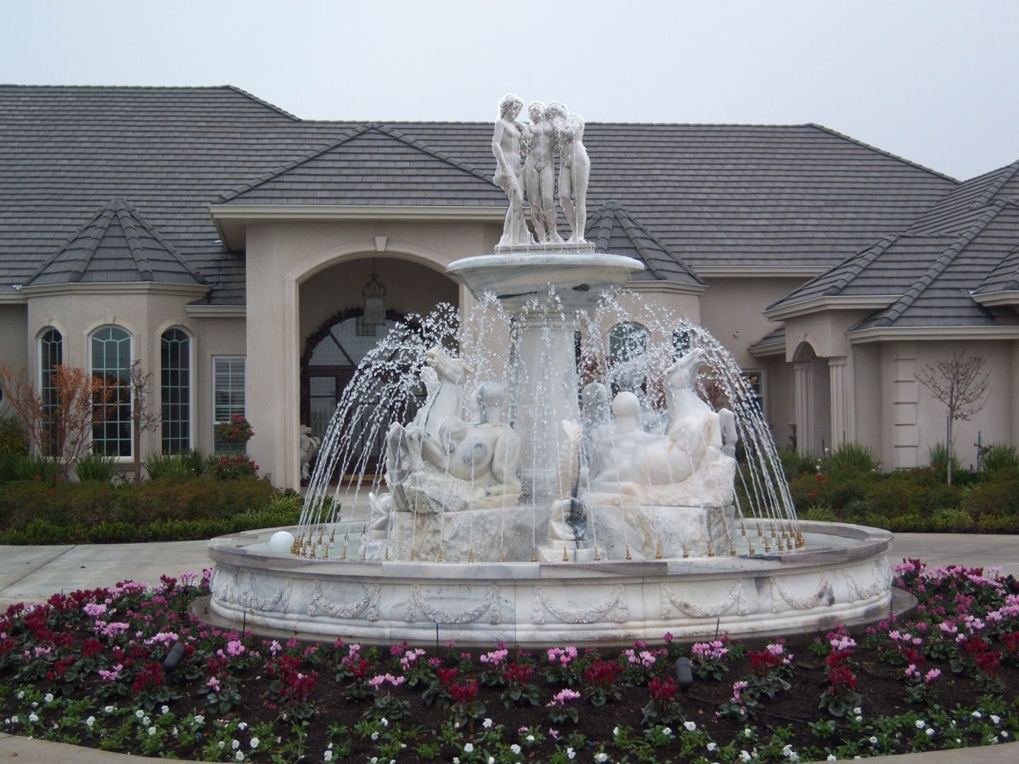 A large fountain in front of a large house
