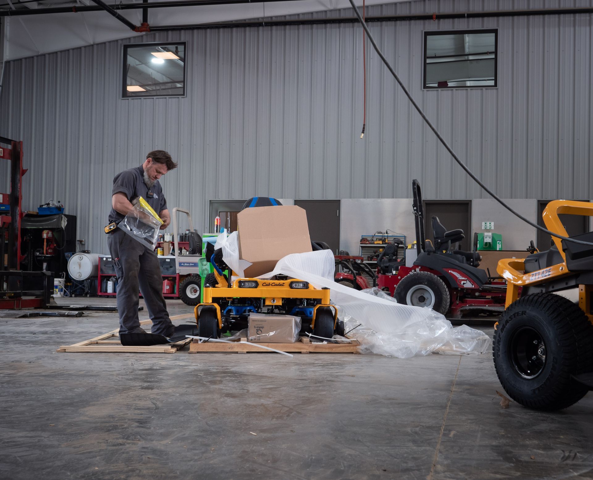 A man is working on a lawn mower in a garage.