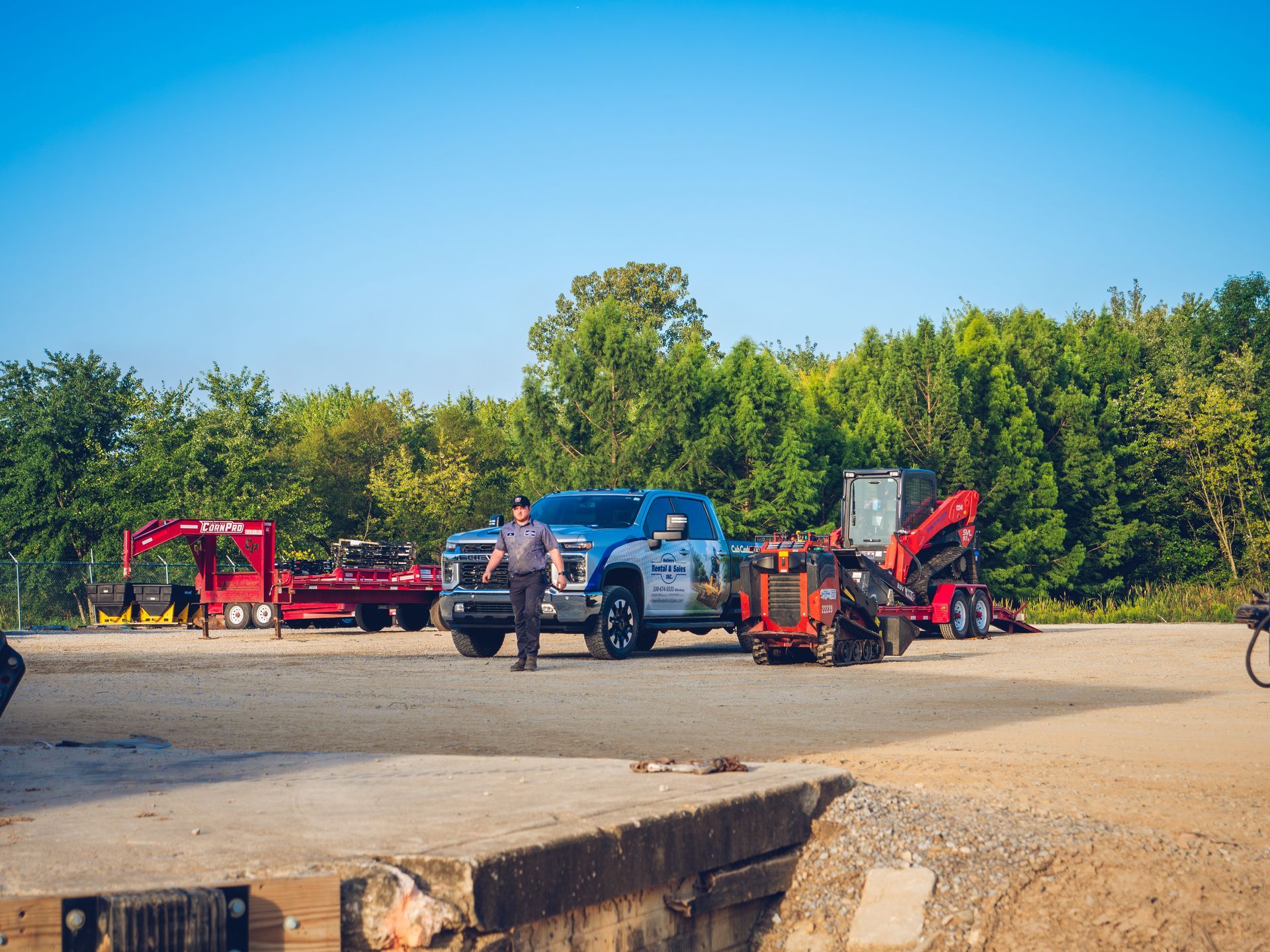 A man is standing next to a truck in a parking lot.