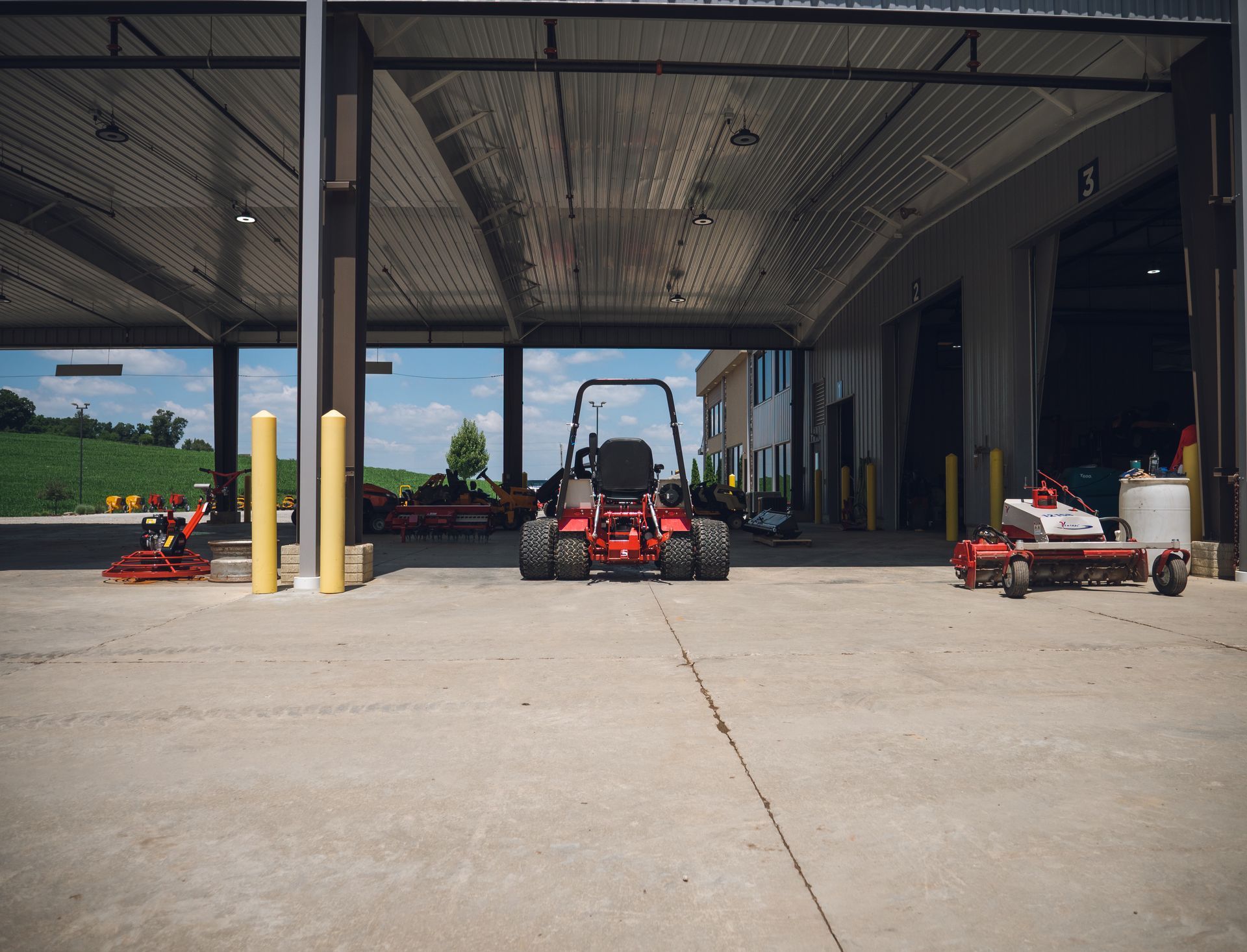 A red lawn mower is parked in a parking lot in front of a building.